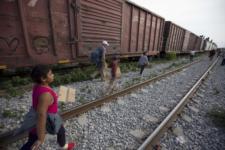 En fotograf&iacute;a del 12 de julio de 2014 se ve a migrantes caminar por las v&iacute;as del tren en Ixtepec, M&eacute;xico, durante su recorrido hacia la frontera entre este pa&iacute;s y Estados Unidos. (Foto de AP/Eduardo Verdugo)