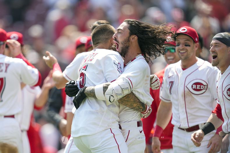 Nick Senzel (centro izquierda) celebra con Jonathan India tras batear el jonrón para la victoria ante los Rangers de Texas, el miércoles 26 de abril de 2023, en Cincinnati. (AP Foto/Jeff Dean)