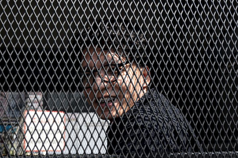 El fotógrafo independiente Natthapon Phanphongsanon en una camioneta policíaca en la estación de policía de Thing Song Hong en Bangkok, Tailandia, el martes 13 de febrero de 2024. (AP Foto/Tananchai Keawsowattana)