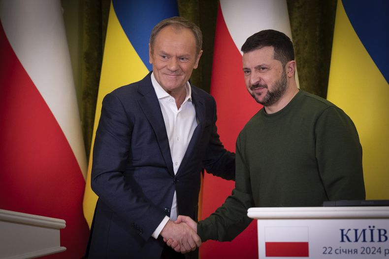El primer ministro de Polonia, Donald Tusk (izquierda), y el presidente de Ucrania, Volodymyr Zelenskyy, estrechan las manos durante una reunión en Kiev, el lunes 22 de enero de 2024. (Oficina de prensa de la presidencia de Ucrania vía AP)