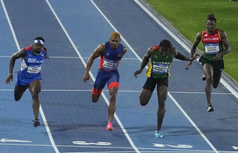 El guyanés Emanuel Archibald (3ro de izquierda a derecha) gana los 100 metros en los Juegos Centroamericanos y del Caribe en San Salvador, el lunes 3 de julio de 2023 (AP Foto/Arnulfo Franco)