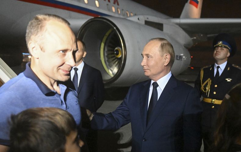 El presidente ruso Vladímir Putin, a la derecha, recibe a Artyom Dultsev, izquierda, a su llegada al aeropuerto de Vnukovo, en las afueras de Moscú, Rusia, el 1 de agosto de 2024, tras un intercambio de prisioneros con EEUU. (Mikhail Voskresensky, Sputnik, Kremlin Pool Photo vía AP)