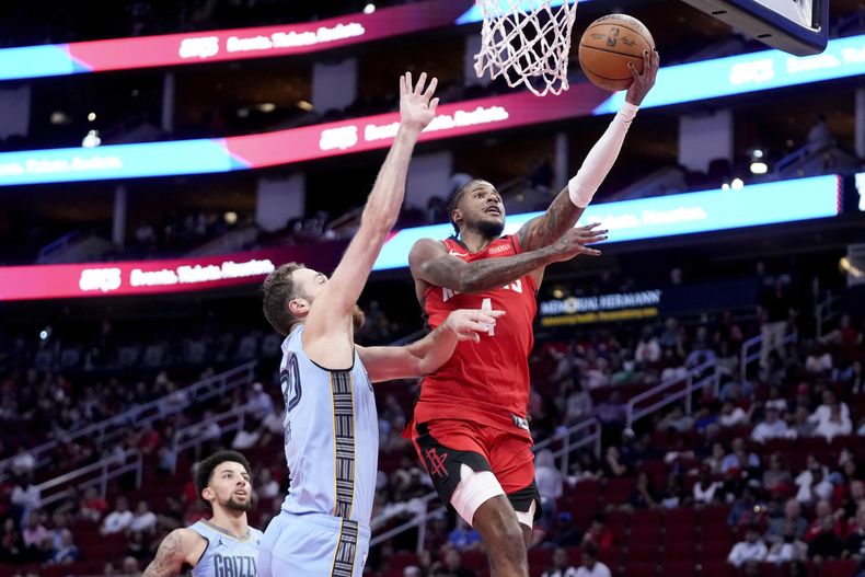 Jalen Green, derecha, de los Rockets de Houston, se alista para una bandeja, mientras Jay Huff, de los Grizzlies de Memphis intenta defender el aro, durante la primera mitad del partido de baloncesto de la NBA, el viernes 25 de octubre de 2024, en Houston. (AP Foto/Eric Christian Smith)