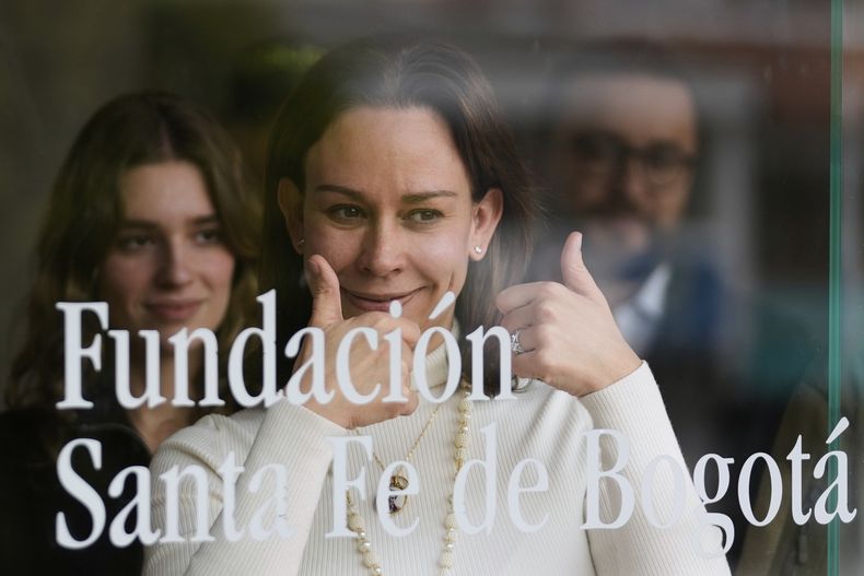 ARCHIVO - Maria Claudia Tarazona, esposa del precandidato y senador colombiano Miguel Uribe Turbay, interactúa con simpatizantes a través de la ventana en la clínica donde su esposo es asistido luego de haber sido malherido a tiros en un mitin en Bogotá, Colombia, el viernes 27 de junio de 2025. (AP Foto/Fernando Vergara, Archivo)