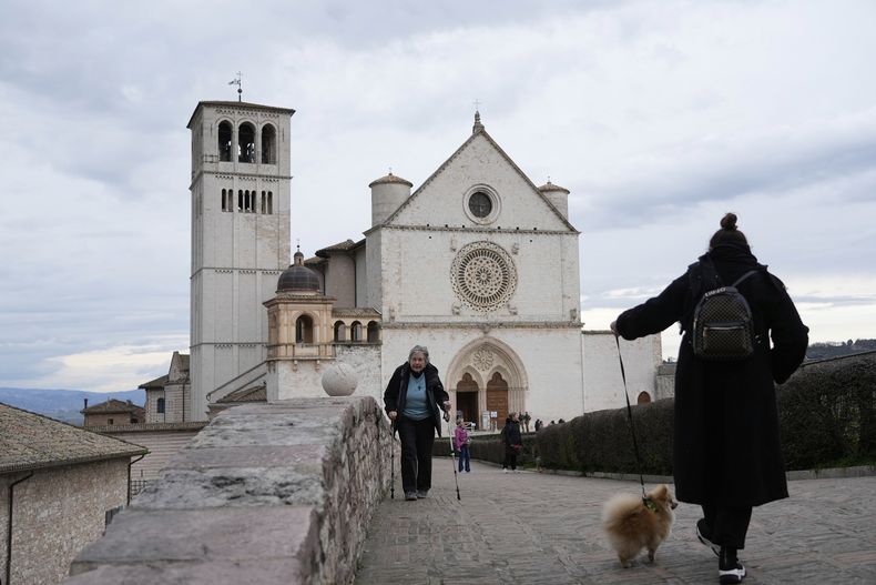 Visitantes caminan cerca de la Basílica de San Francisco en Asís, Italia, el sábado 1 de marzo de 2025. (AP Foto/Gregorio Borgia)