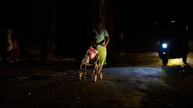 Una mujer empuja un carro al cruzar la calle durante un apagón en La Habana, Cuba, el viernes 18 de septiembre de 2026. (AP Foto/Ramón Espinosa)
