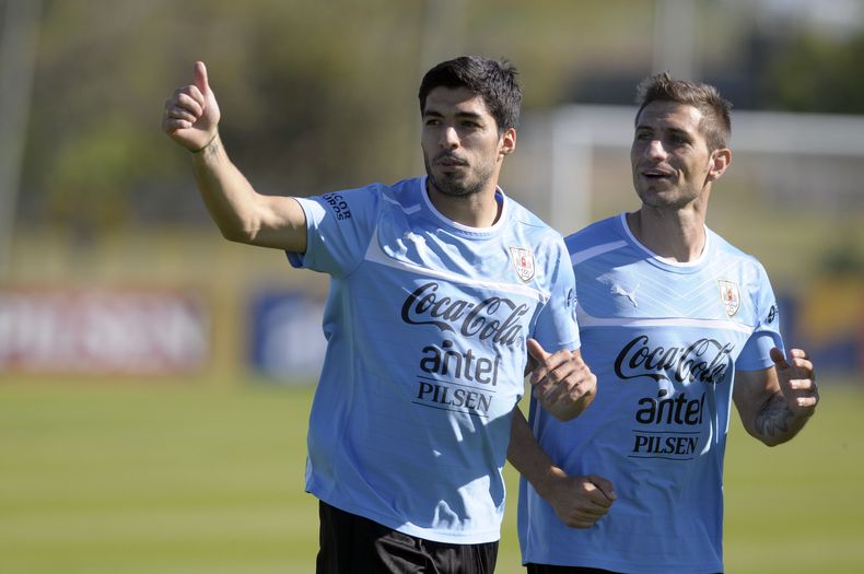 El jugador de Uruguay, Luis Su&aacute;rez, izquierda, saluda mientras trota con su compa&ntilde;ero Sebasti&aacute;n Eguren en un entrenamiento con la selecci&oacute;n uruguaya el lunes, 7 de octubre de 2013, en Montevideo. (AP Photo/Matilde Campodonico)