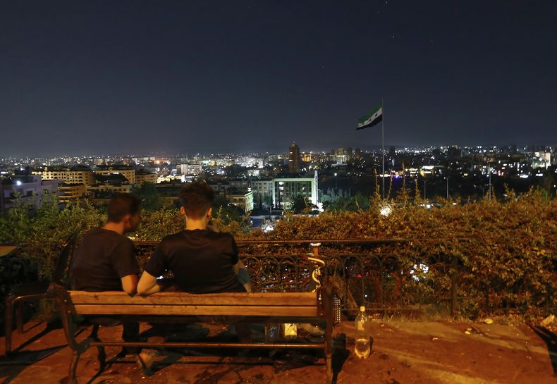 Ciudadanos sirios se reúnen en un parque público mientras esperan ver los misiles iraníes disparados contra Israel cruzar el espacio aéreo de Damasco, Siria, el lunes 16 de junio de 2025. (AP Foto/Omar Sanadiki)