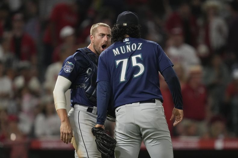 El cátcher Tom Murphy felicita al lanzador mexicano Andrés Muñoz (75), tras conseguir el último out del duelo ante los Angelinos de Los Ángeles, el sábado 5 de agosto de 2023 (AP Foto/Ashley Landis)