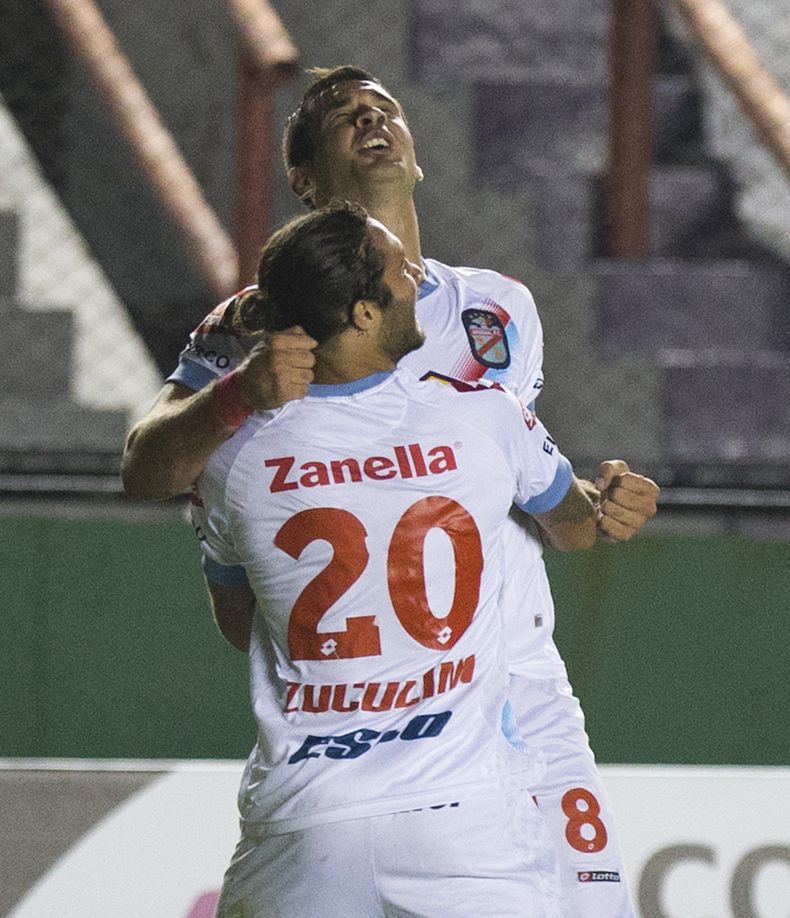 Milton Caraglio, del Arsenal de Argentina, recibe el abrazo de su compa&ntilde;ero Franco Zuculini luego de anotar un gol frente al Deportivo Anzo&aacute;tegui de Venezuela en un partido de la Copa Libertadores, el martes 25 de febrero de 2014 (AP Foto/Ed