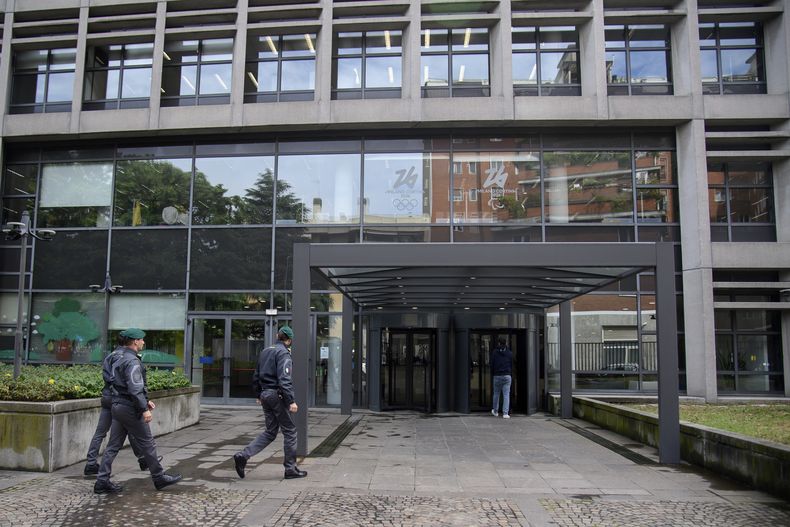 Agentes de la policía financiera caminan frente a las oficinas del comité organizador de los Juegos Olímpicos de Invierno de 2026 Milán-Cortina, el martes 21 de mayo de 2024 (Claudio Furlan/LaPresse via AP)
