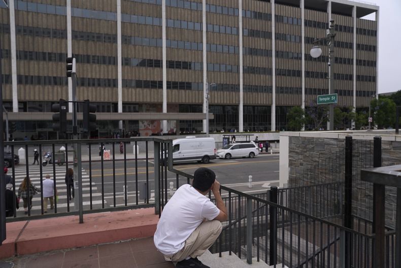 Personas hacen fila fuera de un edificio federal que alberga las oficinas del Servicio de Inmigración y Control de Aduanas de Estados Unidos (ICE) y los Servicios de Ciudadanía e Inmigración (USCIS), el miércoles 25 de junio de 2025, en Los Ángeles. (AP Foto/Damian Dovarganes)