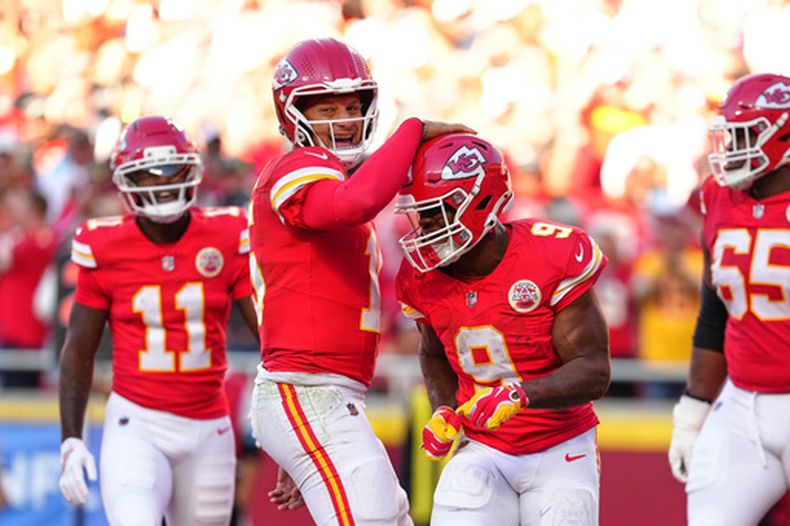 El quarterback de los Chiefs de Kansas City, Patrick Mahomes, al centro a la izquierda, y Kenneth Walker III (9) celebran un touchdown anotado en una jugada por carrera por Walker III durante la primera mitad de un partido de fútbol americano de la NFL contra los Chargers de Los Ángeles en Kansas City, Misuri, el domingo 18 de octubre de 2026. (Foto AP/Ed Zurga)