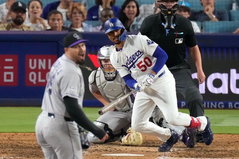 Mookie Betts, derecha, de los Dodgers de Los Ángeles, batea un sencillo productor mientras Antonio Senzatela, izquierda, de los Rockies de Colorado, reacciona durante la octava entrada del juego de béisol de Grandes Ligas, el miércoles 8 de julio de 2026, en Los Ángeles. (AP Foto/Mark J. Terrill)
