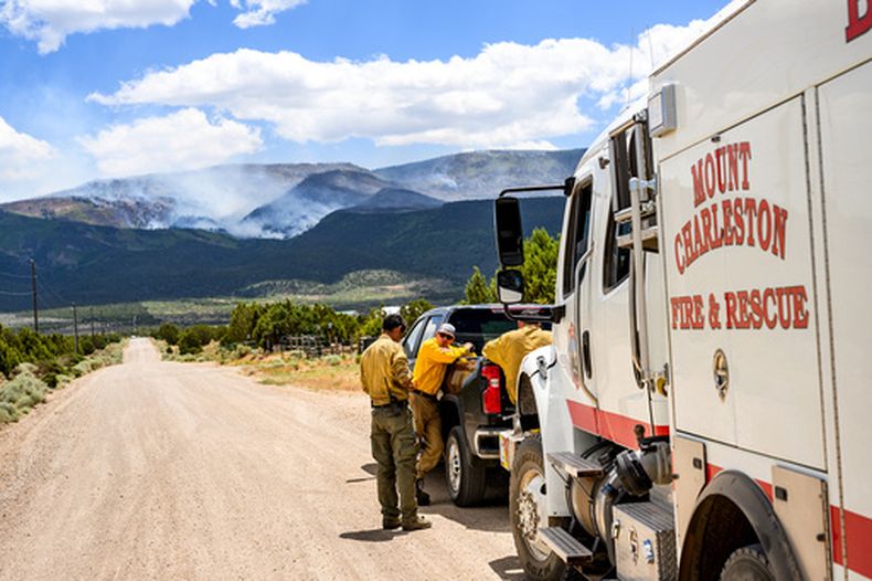 Varios bomberos se reúnen mientras el incendio Cottonwood arde cerca de Beaver, Utah, el sábado 27 de junio de 2026. (AP Foto/Noah Berger)