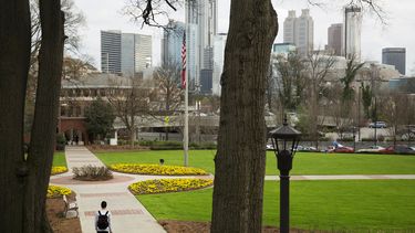 ARCHIVO - Una persona camina por el campus del Instituto de Tecnología de Georgia con el horizonte del centro de la ciudad de fondo, el 11 de marzo de 2016, en Atlanta. (AP foto/David Goldman, archivo)