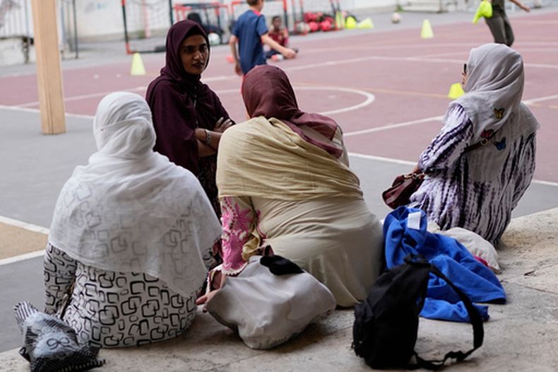Jannatur Nayeem (arriba a la izquierda), una ciudadana italiana de origen bangladeshí, espera con otras madres para que termine una clase deportiva en una escuela en Roma el 24 de septiembre del 2026. (AP foto/Alessandra Tarantino)