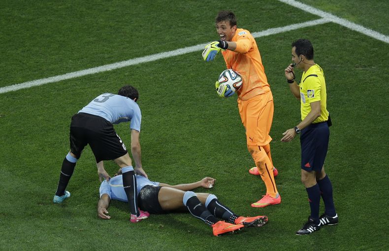 El jugador de Uruguay, Alvaro Pereira, aparece tendido en el suelo tras recibir un golpe en la cabeza en un partido contra Inglaterra el jueves, 19 de junio de 2014, en Sao Paulo. (AP Photo/Michael Sohn)