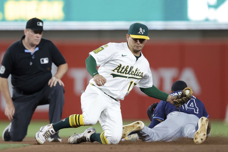 El mexicano Luis Urías, de los Atléticos, trata de poner out a Chandler Cimpson, de los Rays de Tampa Bay, en el encuentro del lunes 11 de agosto de 2025 (AP Foto/Sergio Estrada)
