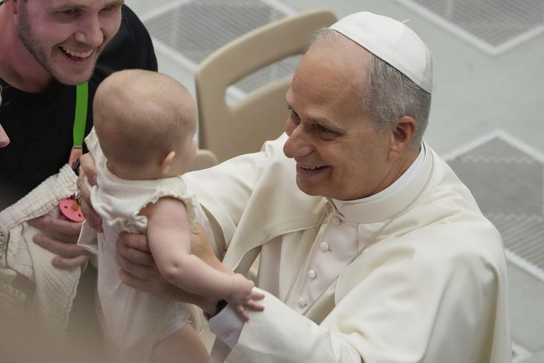 El papa León XIV sostiene a una bebé durante su audiencia general semanal, el miércoles 27 de agosto de 2025, en el Vaticano. (AP Foto/Gregorio Borgia)