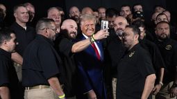 El candidato presidencial republicano Donald Trump sonríe para una selfie con miembros de la Patrulla Fronteriza de Estados Unidos antes de hablar en un mitin de campaña, el domingo 13 de octubre de 2024, en Prescott Valley, Arizona. (AP Foto/Evan Vucci)
