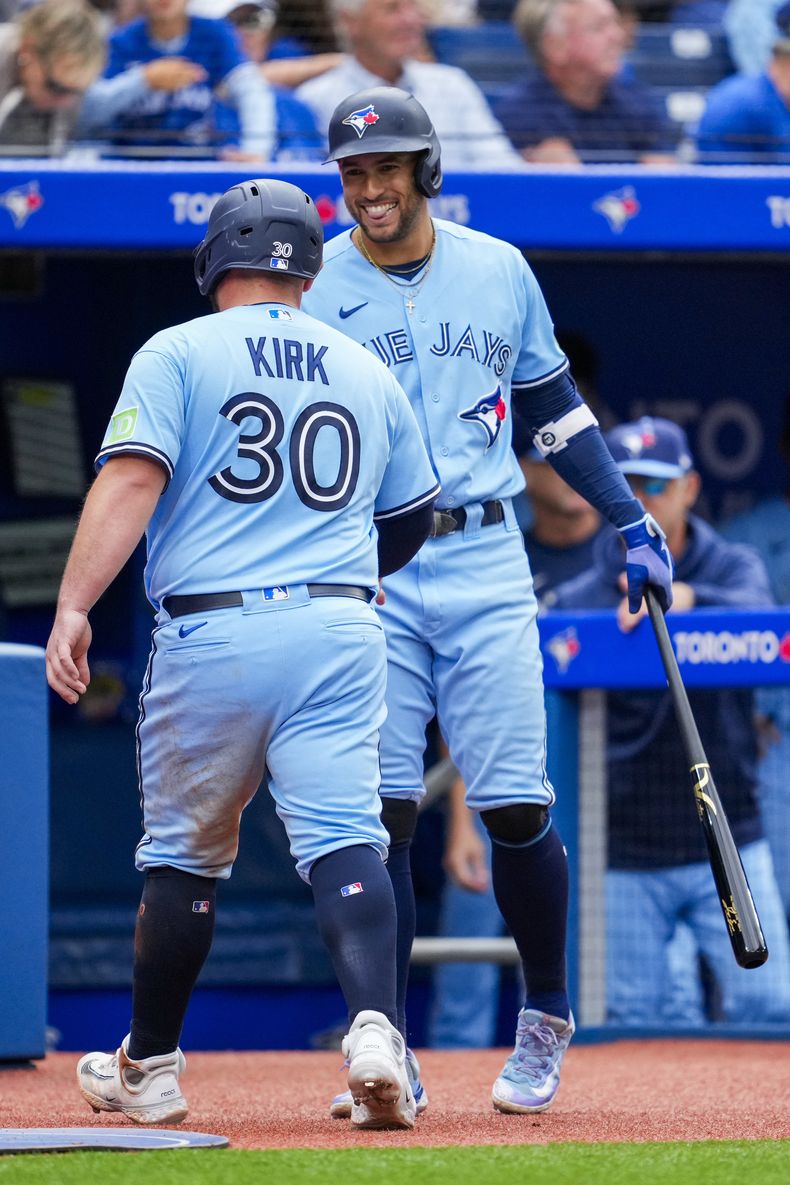 El mexicano Alejandro Kirk festeja con George Springer, su compañero en los Azulejos de Toronto, luego de anotar en el juego del miércoles 30 de agosto de 2023, ante los Nacionales de Washington (Andrew Lahodynskyj/The Canadian Press via AP)