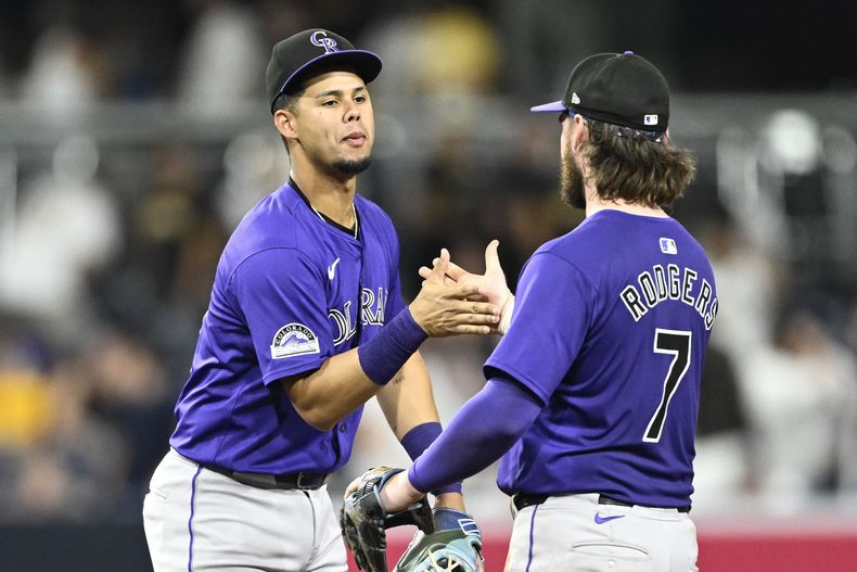 El venezolano de los Rockies de Colorado Ezequiel Tovar y Brendan Rodgers se dan la mano tras la victoria ante los Padres de San Diego el viernes 2 de agosto del 2024. (AP Foto/Denis Poroy)