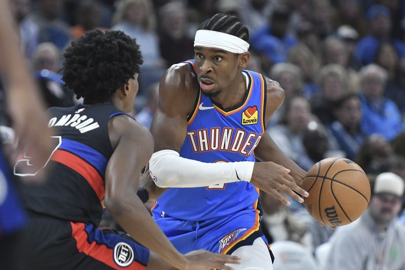 El jugador del Thunder de Oklahoma City Shai Gilgeous-Alexander, a la derecha, intenta eludir al jugador de los Pistons de Detroit Ausar Thompson, en la primera mitad del juego de NBA el 30 de octubre de 2023 en Oklahoma Ciy. (AP Foto/Kyle Phillips)
