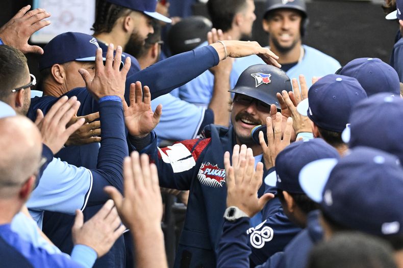 Davis Schneider, de los Azulejos de Toronto, en el centro a la derecha, celebra en el dugout después de conectar un jonrón de dos carreras contra los Medias Blancas de Chicago durante la novena entrada del juego de béisbol, el lunes 27 de mayo de 2024, en Chicago. (AP Foto/Matt Marton)