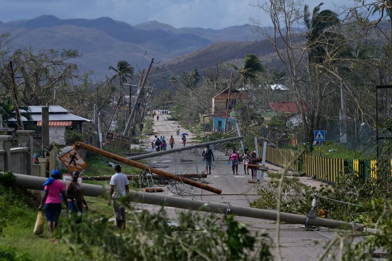 Residentes caminan por Lacovia Tombstone, Jamaica, después del paso del huracán Melissa, el miércoles 29 de octubre de 2025. (AP Foto/Matías Delacroix)