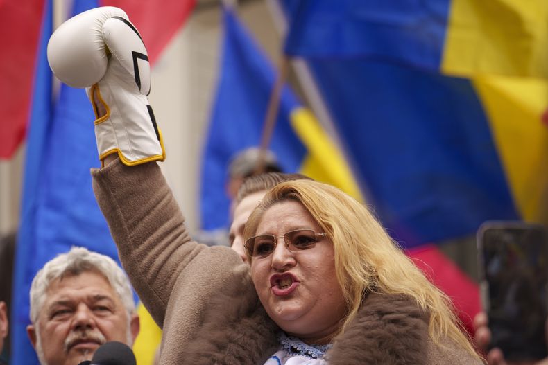 La controvertida política Diana Sosoaca, a quien un tribunal superior le prohibió participar en la elección presidencial del año pasado, levanta la manos, enfundada en un guante de boxeo, mientras habla fuera de la sede de la autoridad electoral del país tras registrarse en un improbable intento de participar en la repetición de la elección, que se realizará en mayo, en Bucarest, Rumania, el jueves 13 de marzo de 2025. (AP Foto/Vadim Ghirda)