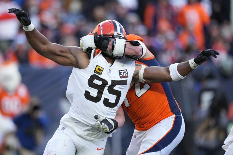 Myles Garrett (95), defensive end de los Browns de Cleveland, presiona al quarterback de los Broncos de Denver, mientras el offensive tackle Garett Bolles (72) lo bloquea durante la primera mitad del juego de la NFL, el domingo 26 de noviembre de 2023, en Denver. (AP Foto/Jack Dempsey)