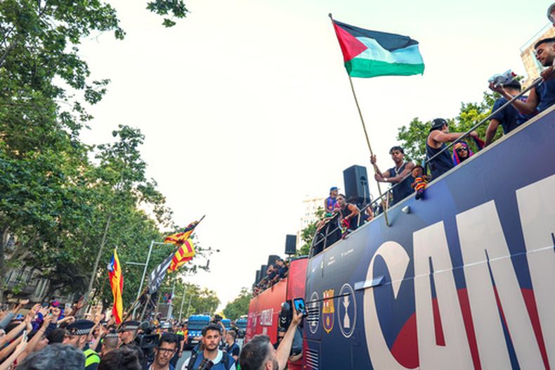 El astro del Barcelona Lamine Yamal sostiene una bandera palestina al celebrar la consagración del equipo como campeones de la Liga de España, el lunes 11 de mayo de 2026, en Barcelona. (AP Foto)