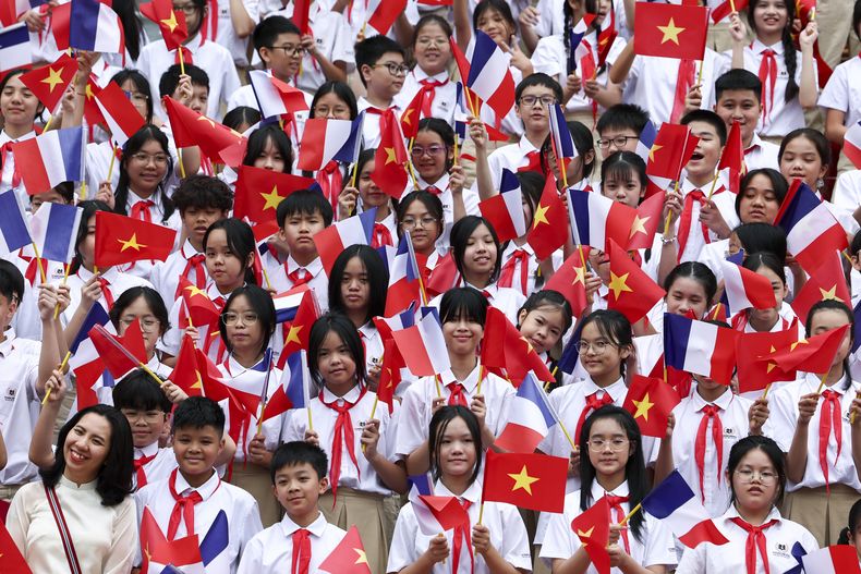 Niños sostienen banderas de Vietnam y Francia en una ceremonia de bienvenida para el presidente de Francia, Emmanuel Macron, en el Palacio Presidencial de Hanoi, Vietnam, el lunes 26 de mayo de 2025. (Chalinee Thirasupa/Pool Foto via AP)