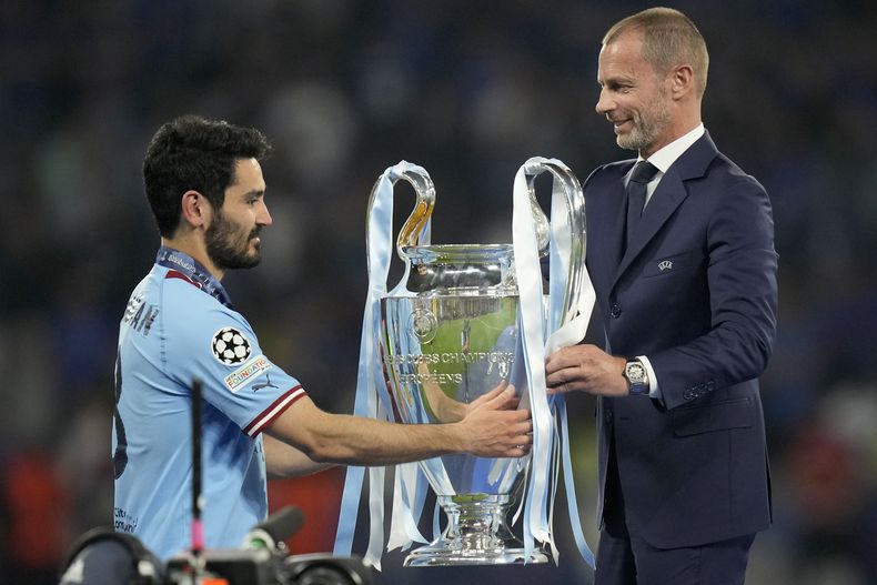 El presidente de la UEFA Aleksander Ceferin entrega el trofeo al capitán del Manchester City Ilkay Gundogan tras su victoria en la final de la Liga de Campeones ante el Inter de Milán, el sábado 10 de junio de 2013, en Estambul. (AP Foto/Francisco Seco)