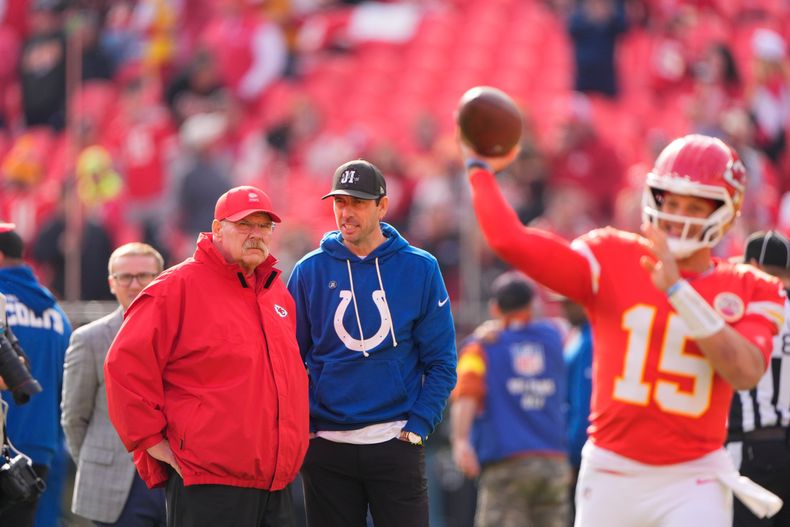 El entrenador Andy Reid (izquierda) de los Chiefs de Kansas City y Shane Steichen, su contraparte de los Colts de Indianápolis, charlan mientras el quarterback Patrick Mahomes (15) se apresta para un partido de la NFL, el domingo 23 de noviembre de 2025, en Kansas City, Missouri. (AP Foto/Charlie Riedel)