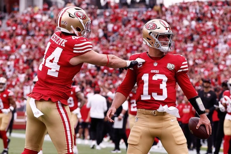 Brock Purdy (13), quarterback de los 49ers de San Francisco, es felicitado por el fullback Kyle Juszczyk (44) después de anotar frente a los Dolphins de Miami durante la primera mitad del partido de la NFL, el domingo 20 de septiembre de 2026, en Santa Clara, California. (AP Foto/Kelley L. Cox)