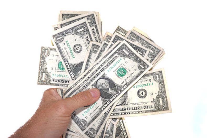 Billetes de un dólar se ven sostenidos en Dallas, el martes 7 de abril de 2026. (AP Foto/LM Otero)