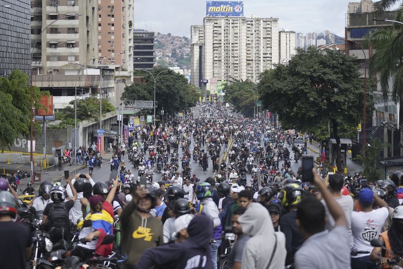 Los manifestantes marchan y viajan en motocicletas en rechazo a los resultados oficiales de las elecciones que declaran ganador al presidente Nicolás Maduro, el día después de las elecciones presidenciales en Caracas, Venezuela, el lunes 29 de julio de 2024. (AP Foto/Fernando Vergara)