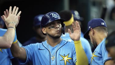 Isaac Paredes, de los Rays de Tampa Bay, es felicitado en la caseta del equipo después de anotar durante la séptima entrada del juego de béisbol en contra de los Tigres de Detroit, el viernes 4 de agosto de 2023, en Detroit. (AP Foto/Carlos Osorio)