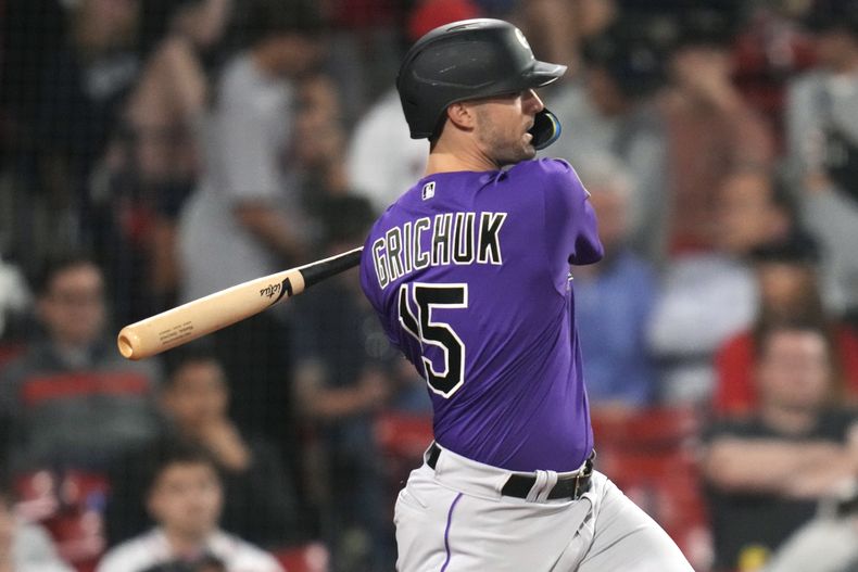 Randal Grichuk, de los Rockies de Colorado, conecta un doble de dos carreras en la décima entrada del juego ante los Medias Rojas de Boston, el martes 13 de junio de 2023 (AP Foto/Charles Krupa)