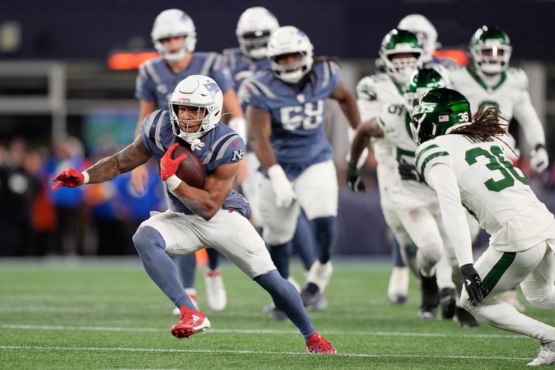 TreVeyon Henderson, corredor de los Patriots de Nueva Inglaterra, acarrea el balón, durante la primera mitad del partido de la NFL en contra de los Jets de Nueva York el jueves 13 de noviembre de 2025, en Foxborough, Massachusetts. (AP Foto/Robert F. Bukaty)