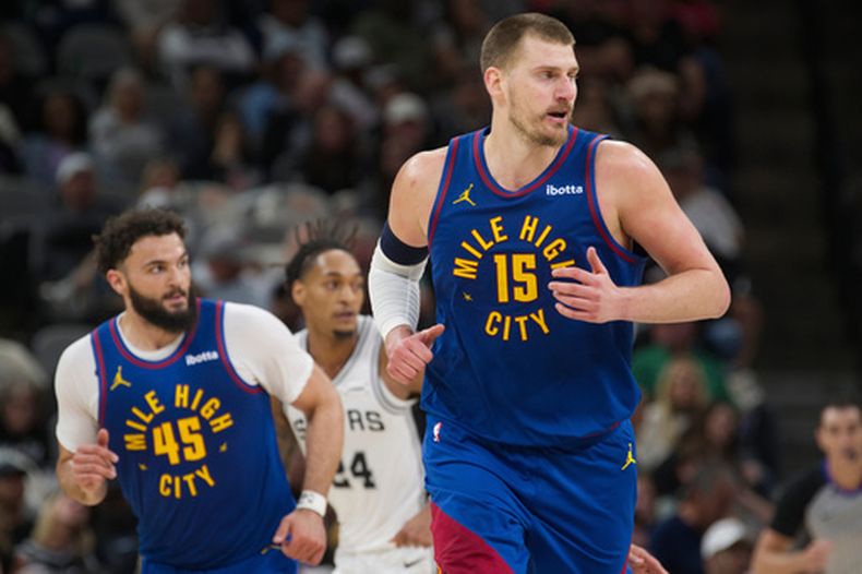 Nikola Jokic (15), de los Nuggets de Denver, corre en la duela durante la primera mitad del juego de baloncesto de la NBA contra los Spurs de San Antonio, el domingo 12 de abril de 2026, en San Antonio. (AP Foto/Darren Abate)