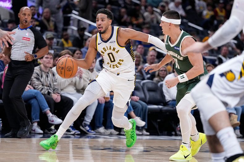 El base de los Pacers de Indiana Tyrese Haliburton avanza hacia la canasta con el balón frente al base de los Bucks de Milwaukee Tyler Herro en el encuentro de pretemporada del viernes 16 de octubre del 2026. (AP Foto/Michael Conroy)
