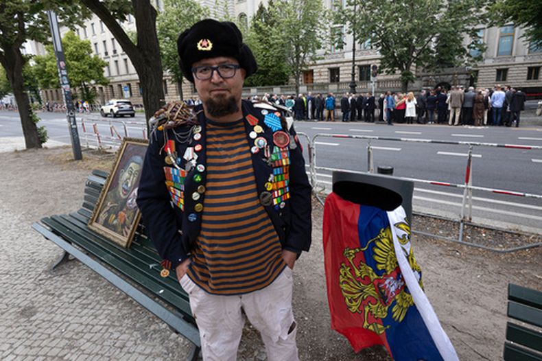 Un hombre identificado por los medios polacos como Robert Kuzovkov posa para una foto con una de sus pinturas cerca de la embajada rusa en Berlín, Alemania, el 12 de junio de 2026, cuatro días antes de que las autoridades polacas informaran que fue asesinado a tiros en Polonia. (Vasily Krestyaninov/SOTA vía AP)