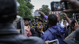 ARCHIVO – Los graduados del Morehouse College desfilan frente a las cámaras de los teléfonos al llegar a la ceremonia de graduación en el campus, el 18 de mayo de 2014, en Atlanta. (John Amis/Atlanta Journal-Constitution vía AP, Archivo)