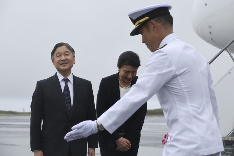 El emperador de Japón, Naruhito, a la izquierda, y la emperatriz, Masako, en el centro, son escoltados por un miembro de las Fuerzas de Autodefensa de Japón, a su llegada a la isla de Iwo Kima, que ahora lleva el nombre oficial de Iwo To, en Japón, el lunes 7 de abril de 2025. (Kim Kyung-Hoon/Pool Foto via AP)