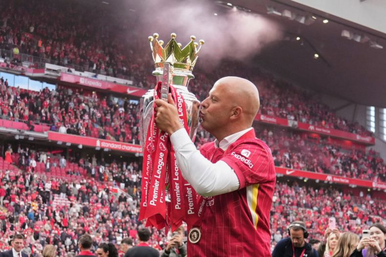 ARCHIVO - El técnico de Liverpool Arne Slot besa el trofeo de campeón de la Liga Premier, el domingo 25 de mayo de 2025, en Liverpool. (AP Foto/Jon Super, File)