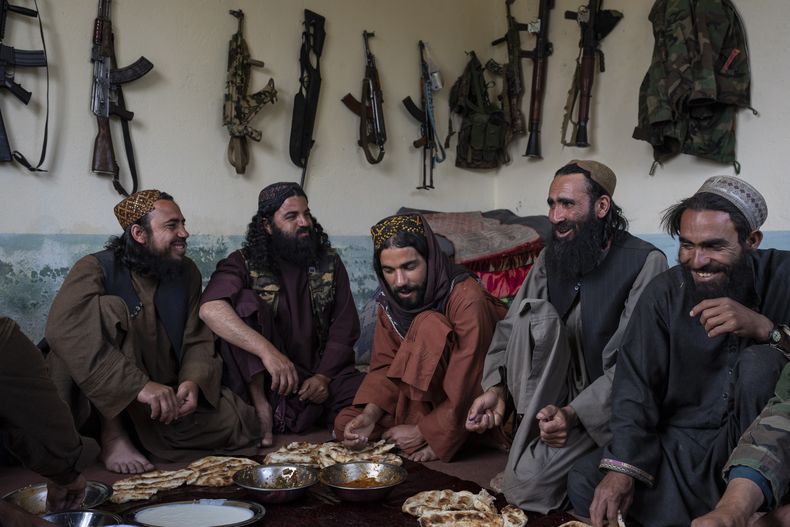 Combatientes talibanes almuerzan en una casa de adobe utilizada como puesto de control improvisado, en la provincia de Wardak, Afganistán, el 22 de junio de 2023. (AP Foto/Rodrigo Abd)