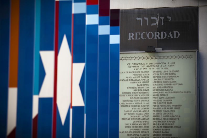 ARCHIVO - Una placa recuerda a las víctimas del ataque terrorista de 1994 contra el centro comunitario judío AMIA en Buenos Aires, Argentina, el 8 de febrero de 2013. Un juez federal argentino pidió a Interpol que detenga a cuatro ciudadanos libaneses presuntamente vinculados con el ataque en el que murieron 85 personas. (AP Foto/Víctor R. Caivano, Archivo)